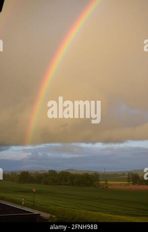 huge rainbow in front of dark clouds Stock Photo