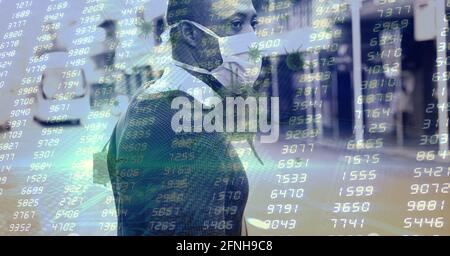 Composition of data processing and covid 19 cell over man wearing face mask in city Stock Photo