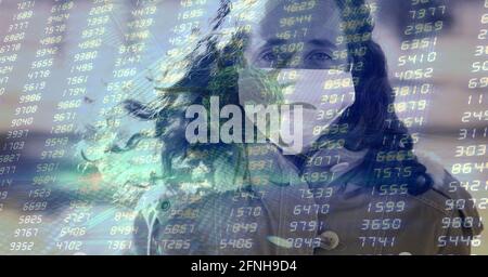 Composition of data processing and covid 19 cell over woman wearing face mask in city Stock Photo