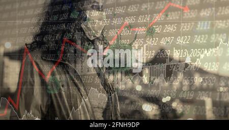 Composition of data processing and covid 19 cell over woman wearing face mask in city Stock Photo