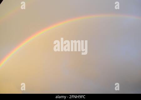 huge rainbow in front of dark clouds Stock Photo