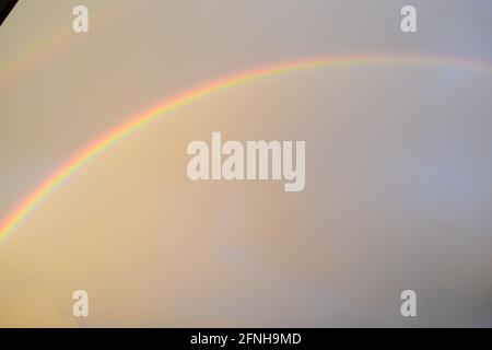 huge rainbow in front of dark clouds Stock Photo