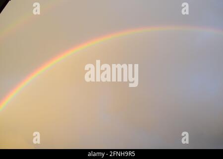 huge rainbow in front of dark clouds Stock Photo