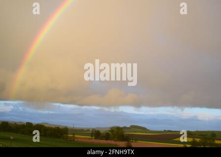 huge rainbow in front of dark clouds Stock Photo