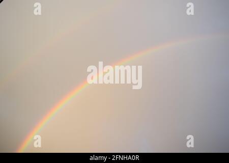 huge rainbow in front of dark clouds Stock Photo