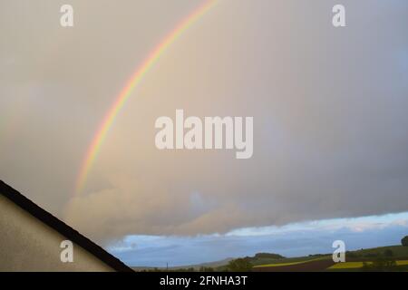 huge rainbow in front of dark clouds Stock Photo