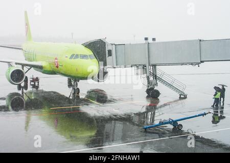 Plane prepares to take passengers to airport in difficult weather conditions Stock Photo