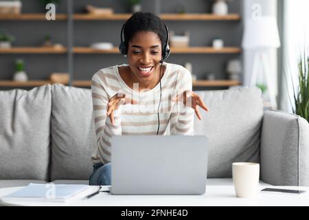Online Conference. Young Black Lady In Headset Having Web Call On Laptop Stock Photo