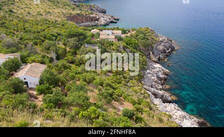 Zingaro Nature Reserve, Trapani, Sicily, Italy. View over coastline of the Gulf of Castellammare from Punta Leone, rural houses clinging to hillside. Stock Photo