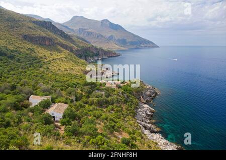 Zingaro Nature Reserve, Trapani, Sicily, Italy. View over coastline of the Gulf of Castellammare from Punta Leone, rural houses clinging to hillside. Stock Photo