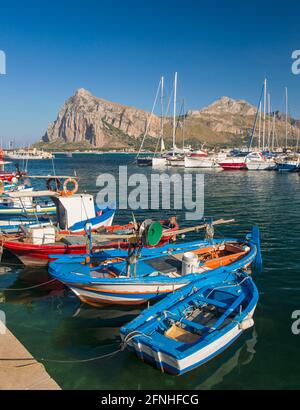 San Vito Lo Capo, Trapani, Sicily, Italy. View across colourful harbour to the towering peaks of Monte Monaco and Pizzo di Sella. Stock Photo