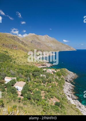 Zingaro Nature Reserve, Trapani, Sicily, Italy. View over coastline of the Gulf of Castellammare from Punta Leone, rural houses clinging to hillside. Stock Photo