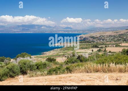 Scopello, Trapani, Sicily, Italy. View across fields to the rugged coastline and deep blue waters of the Gulf of Castellammare. Stock Photo