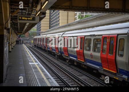 District line tube train arrives in High Street Kensington underground station in London, May 2021 Stock Photo