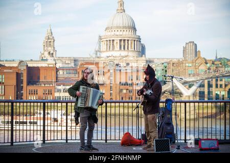 London, UK - 12 April, 2019 - Street musicians on the South Bank with St Paul's Cathedral in the background Stock Photo