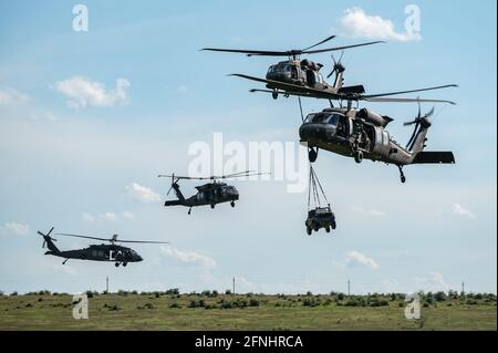 U.s. Army Paratroopers Sling Load An M-119a2 105 Mm Howitzer To A Uh 