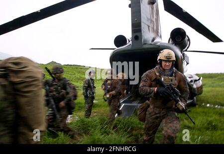 U.S. Marines with the III Marine Expeditionary Force, and Japanese soldiers with Amphibious Rapid Deployment Brigade, exit a JSDF CH-47 Chinook helicopter during a multilateral assault exercise Jeanne D’Arc 21 at Kirishima Maneuver Area, May 15, 2021 in Yamato, Kumamoto, Japan. Stock Photo