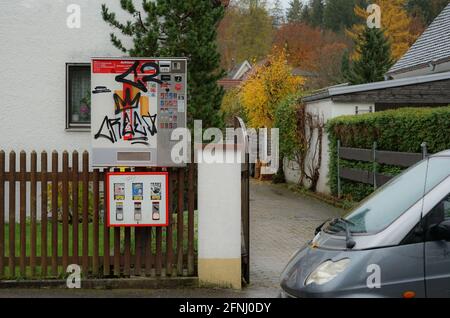 View of a chewing gum vending machine, above a cigarette vending machine in a detached house in a small town. Stock Photo