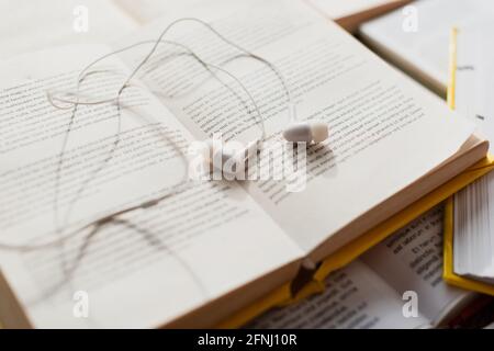 white earphones on stack of blurred books Stock Photo