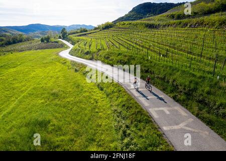 Mother and son cycling on the road in Vipava valley, Slovenia Stock Photo