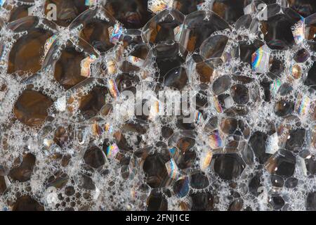 Abstract dark background with big soap bubbles and colorful reflections. Close up. Stock Photo