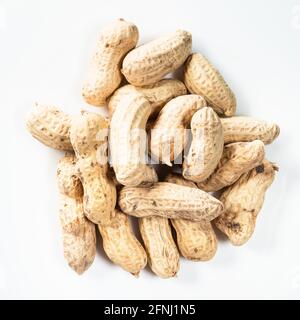 top view of pile of unpeeled peanuts on white background Stock Photo