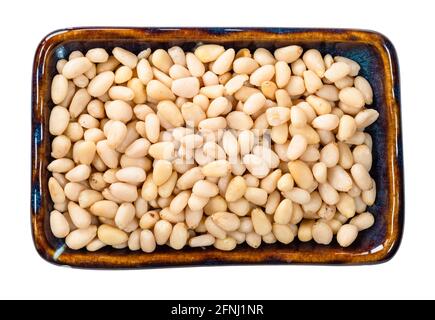 top view of peeled Pine nuts in bowl cutout on white background Stock Photo
