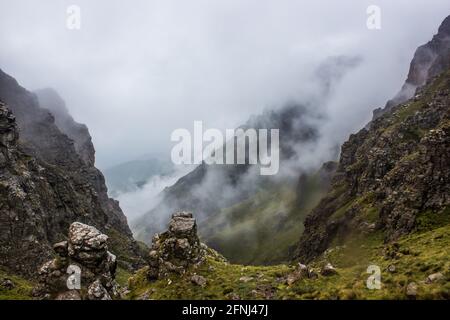 Fog descending in a narrow pass along the high peaks of the Drakensberg Mountains of South Africa Stock Photo