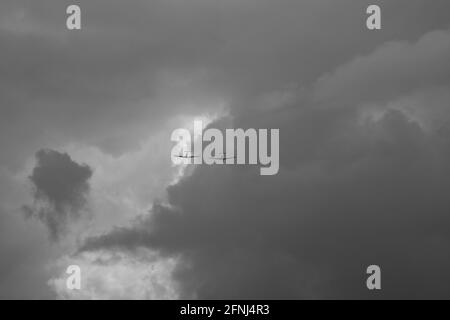 Mono image of two Spitfire fighters wing to wing coming out of the clouds and heading towards the viewer Stock Photo