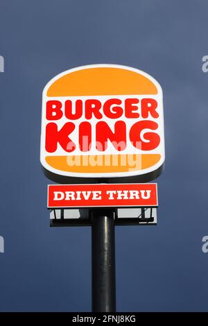 Eskilstuna, Sweden - May 17, 2021: Low angle view of the new rebranded Burger King logo on a pole outside the restaurant with drive thru isolated agai Stock Photo