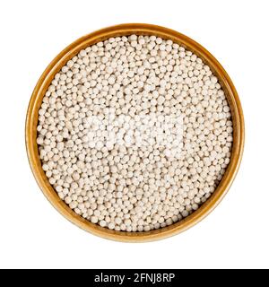 top view of uncooked ptitim (pearl couscous) in round ceramic bowl cutout on white background Stock Photo