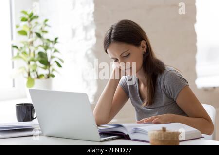 Unhappy teenager bored with studying at home Stock Photo
