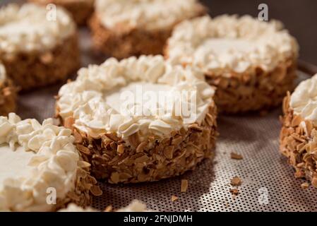 close up of cakes and sweets with whipped cream in pastry shop . concept of traditional manual pastries preparation in traditional bakery factory Stock Photo