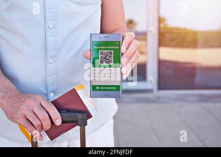 Hand man holding smartphone display on app mobile displaying valid digital vaccination certificate for Covid-19. Immunity vaccine passport, vaccinatio Stock Photo