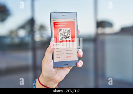 Hand woman holds smartphone displaying an app positive test result of Covid-19. Express PCR test, digital result on mobile application Stock Photo
