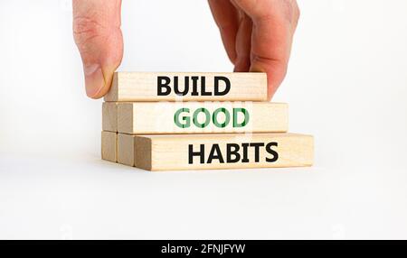 Build good habits symbol. Wooden blocks with words 'build good habits'. Businessman hand. Beautiful white background, copy space. Business, psychologi Stock Photo