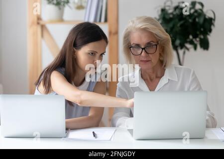 Diverse female colleagues work on laptops brainstorming Stock Photo