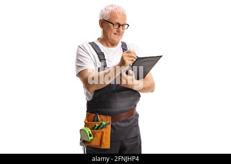 Repairman with a tool belt writing on a clipboard isolated on white background Stock Photo