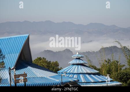 Shan state, Myanmar - January 6 2020: Blue roof of Myat Saytaman traditional bamboohouse in front of a misty valley landscape, Kalaw and Inle Lake Stock Photo