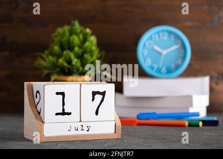 July 17th. July 17 wooden cube calendar with blur objects on background. Stock Photo