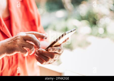 Elderly woman touching phone screen with her finger Stock Photo