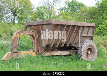 Old rusty agricultural trailer in a field with copy space Stock Photo
