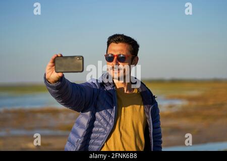young man taking a selfie on the beach Stock Photo