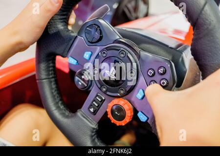 Valencia, Spain - April 16, 2021: Child uses a steering wheel on a Playstation car video game controller. Stock Photo