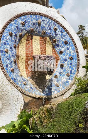 Tile shard mosaic design snake head fountain in Park Güell, Barcelona, Spain Stock Photo