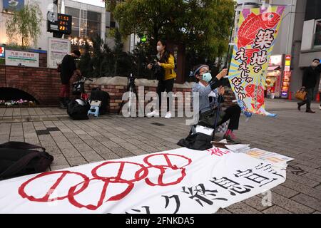 Tokyo, Japan. 17th May, 2021. A protester prepares a banner with 'Save the Tsukiji Market' during an anti Tokyo 2020 Olympic Games Rally in front of Shinbashi Station. The Tsukiji Market was moved from it's original location due to the Olympics.Around 30 to 40 protesters took to the streets calling for the cancelation of the Olympic Games this summer. They were accompanied by the same number of police officers. Protesters went from Shinbashi station through the Ginza district to the Head Office of the Organization Committee for the Games. Credit: SOPA Images Limited/Alamy Live News Stock Photo