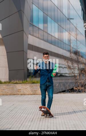 Full length portrait of a businessman smiling and riding a skateboard Stock Photo