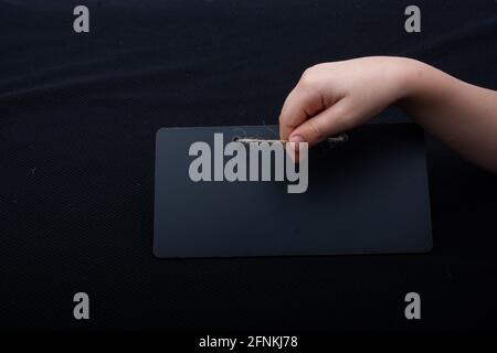 Rectangular shaped black notice board in hand on black background Stock Photo