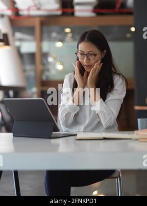Young businesswoman getting exited about the work project in office room Stock Photo