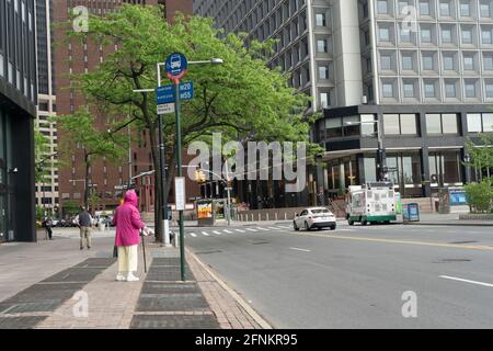 An elderly woman waiting for a bus on Water Street in Lower Manhattan, New York City. Stock Photo